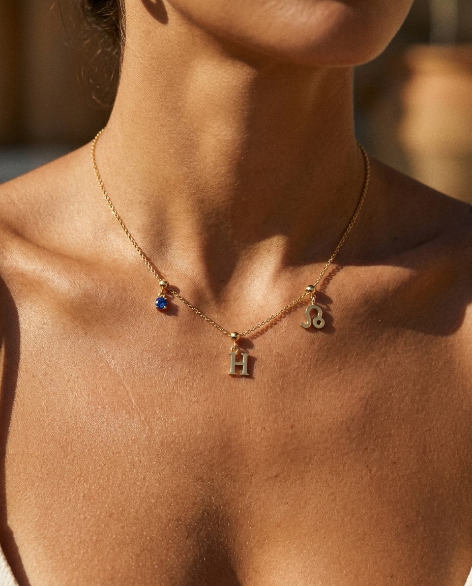Gold initial H charm station necklace on model with Leo zodiac and sapphire
