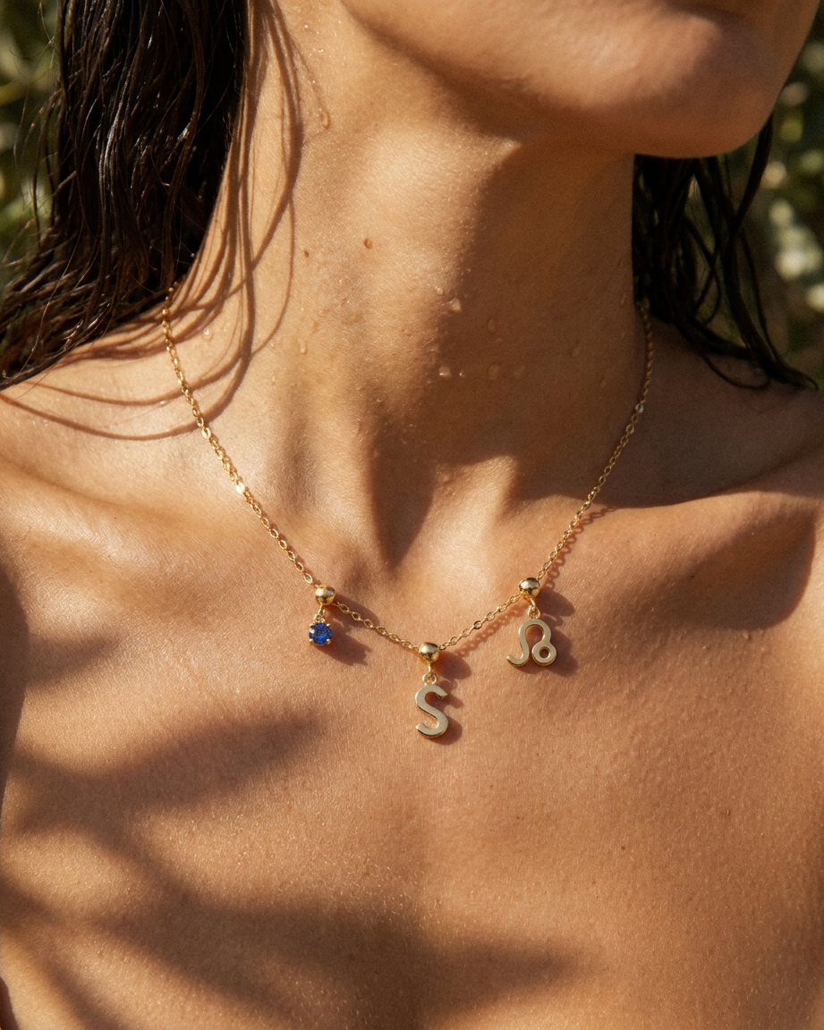 Gold initial S charm station necklace on model with Leo zodiac and sapphire