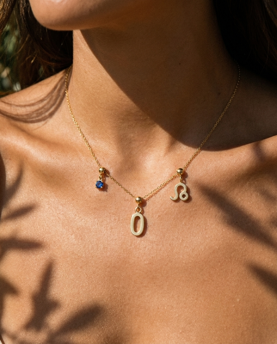 Gold number 0 charm station necklace on model with Leo zodiac and sapphire