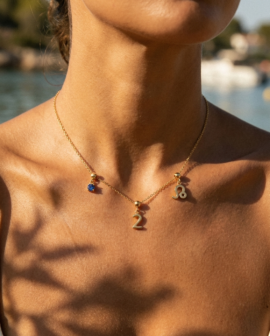 Gold number 2 charm station necklace on model with Leo zodiac and sapphire
