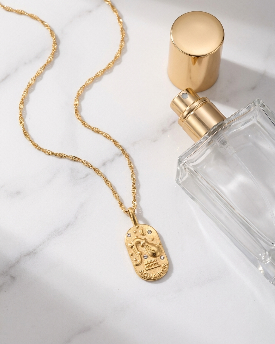Gold zodiac Aquarius pendant necklace flatlay, marble
