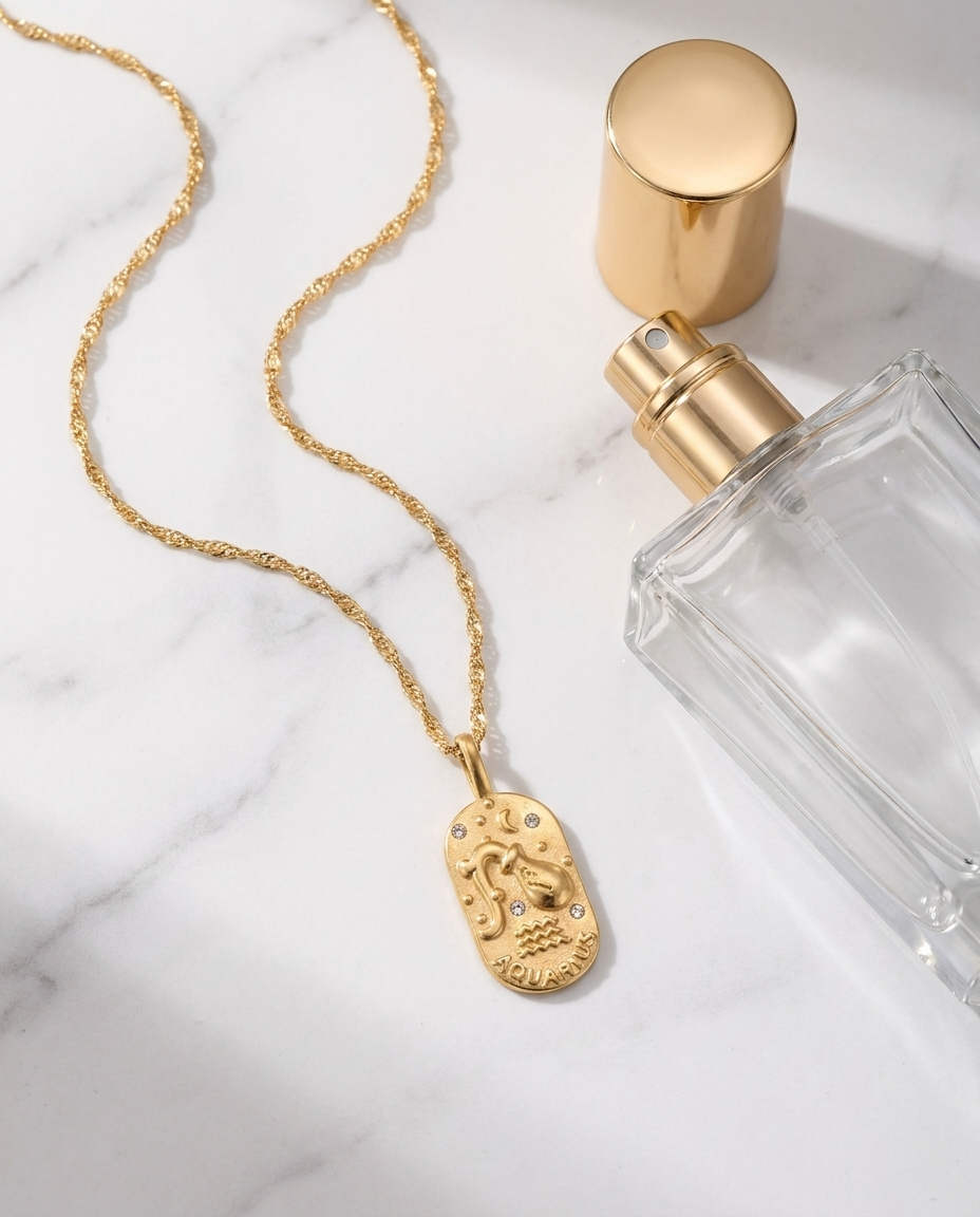 Gold zodiac Aquarius pendant necklace flatlay, marble