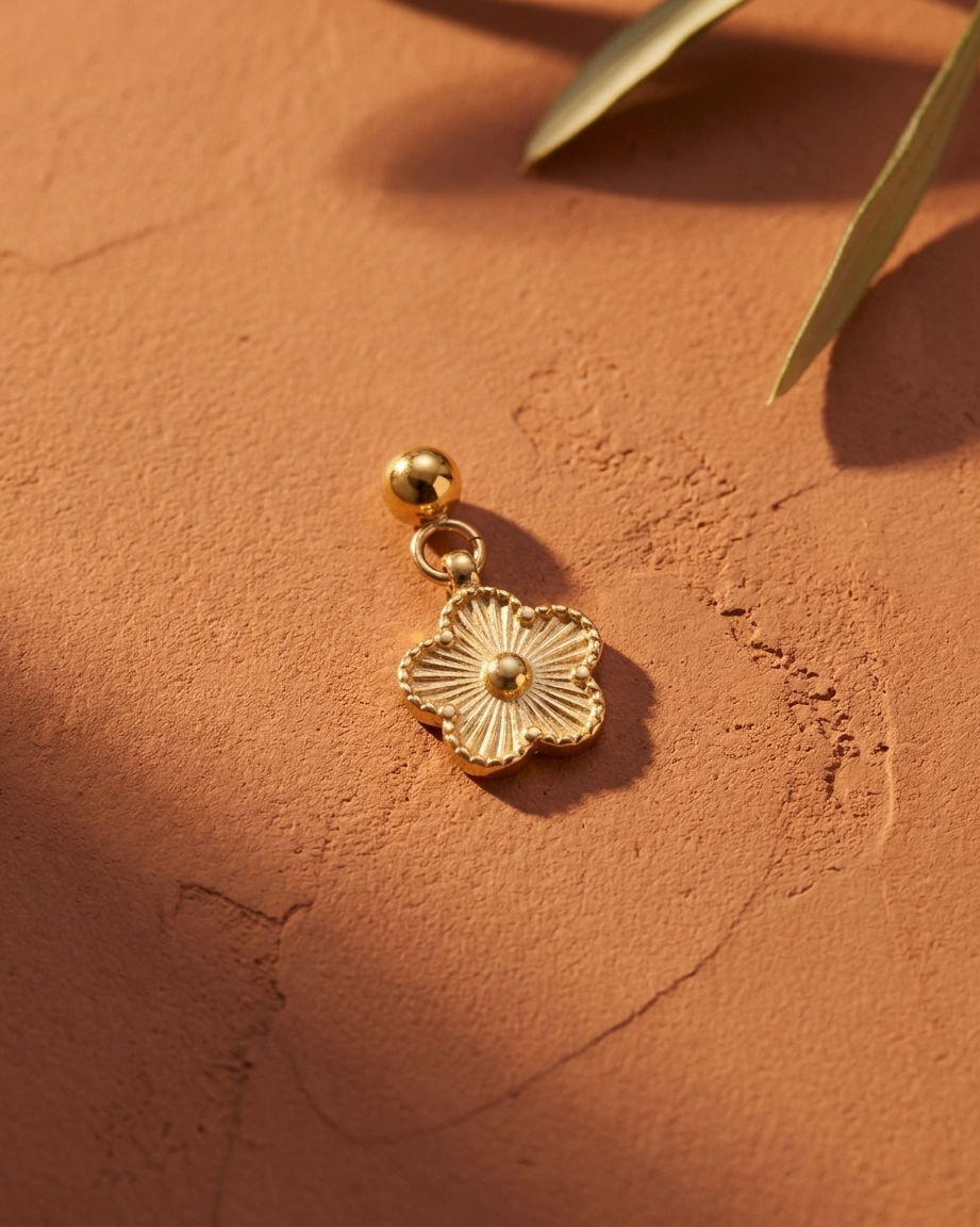 Gold daisy charm flatlay, terracotta