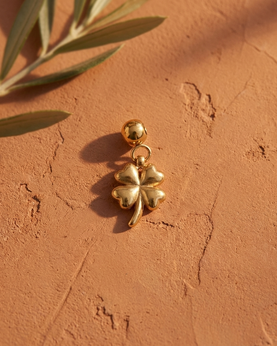 Gold quatrefoil flower charm flatlay, terracotta