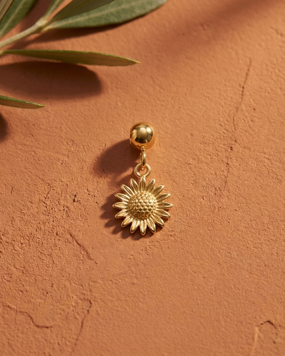 Gold sunflower charm flatlay, terracotta