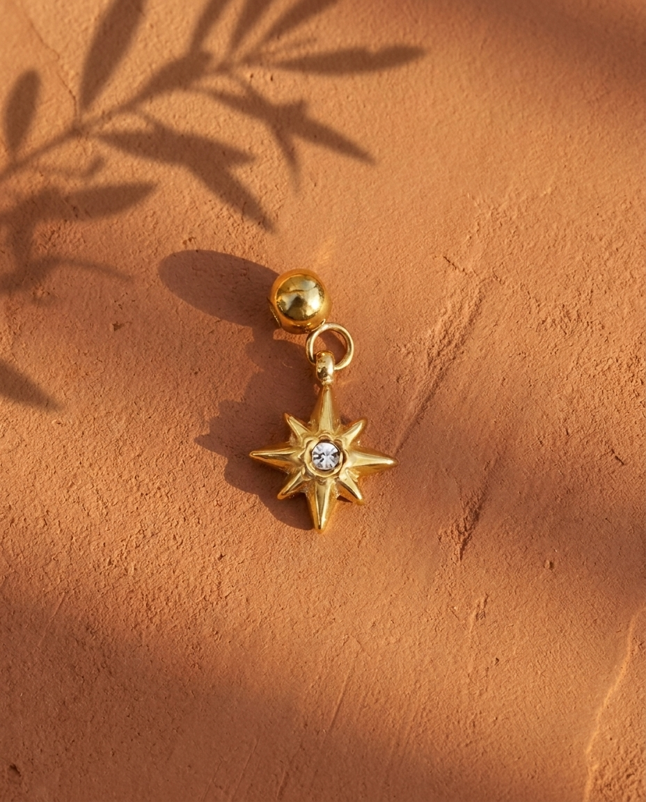 Gold compass star charm flatlay, terracotta