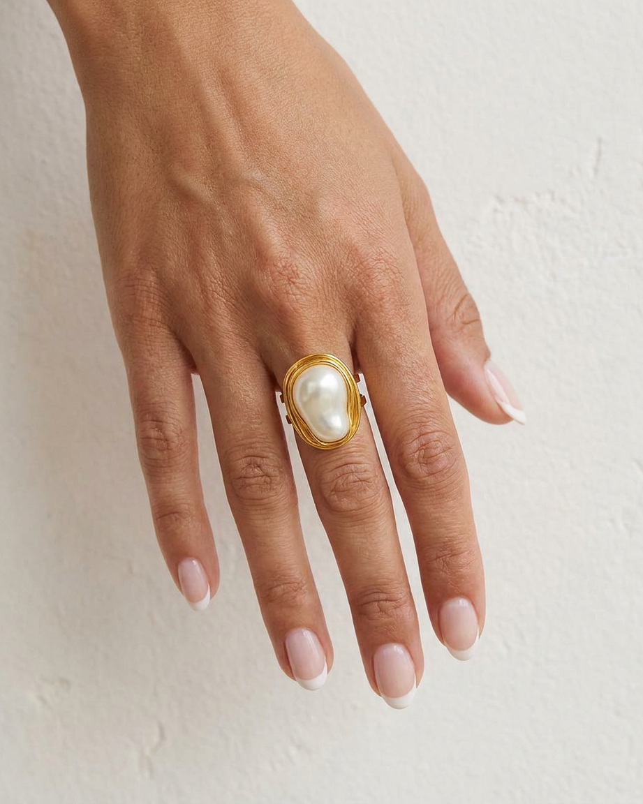 Camelia Gold Pearl Ring on hand against cream wall
