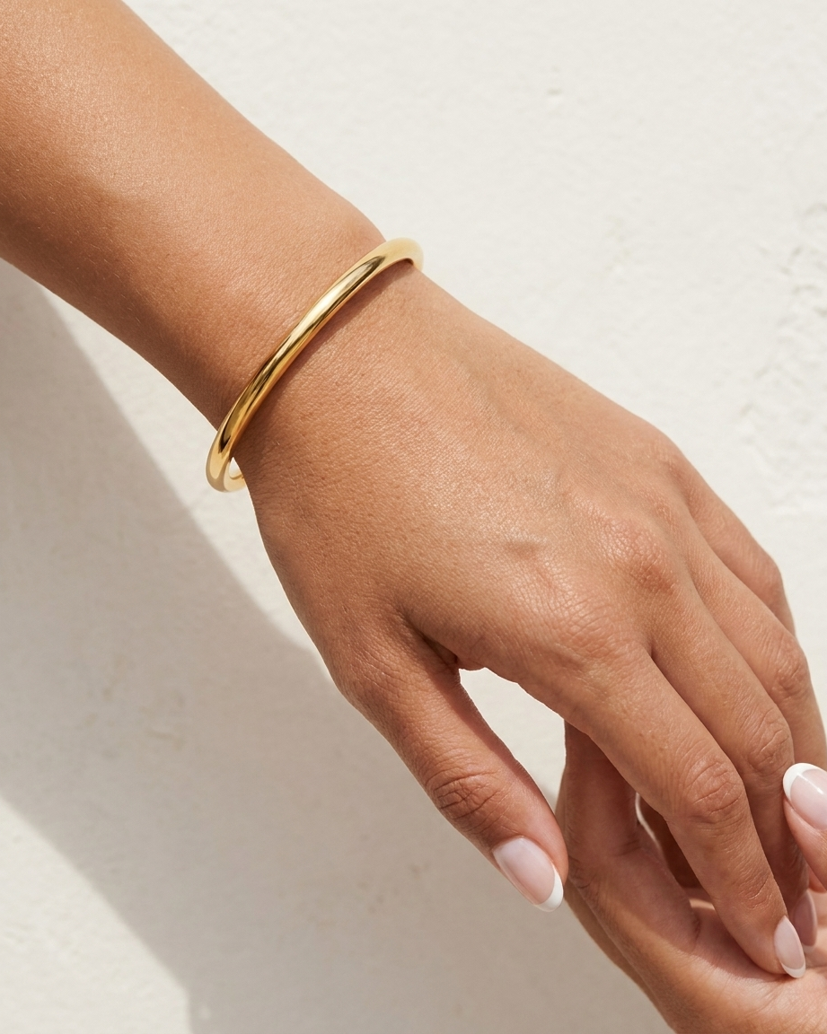 Solene Gold Bangle cream wall wrist