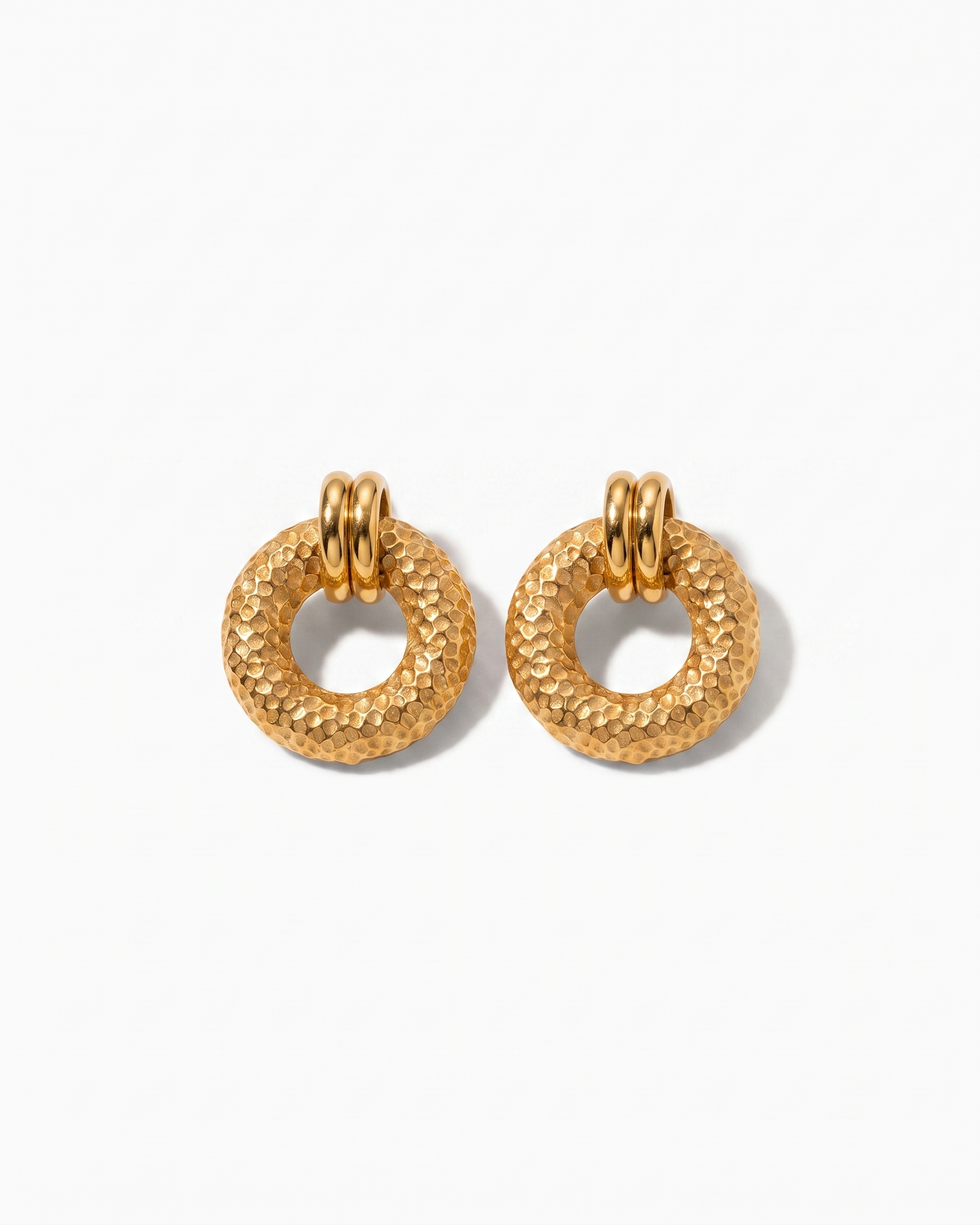 Cleo hammered gold disc earrings pair on off white background