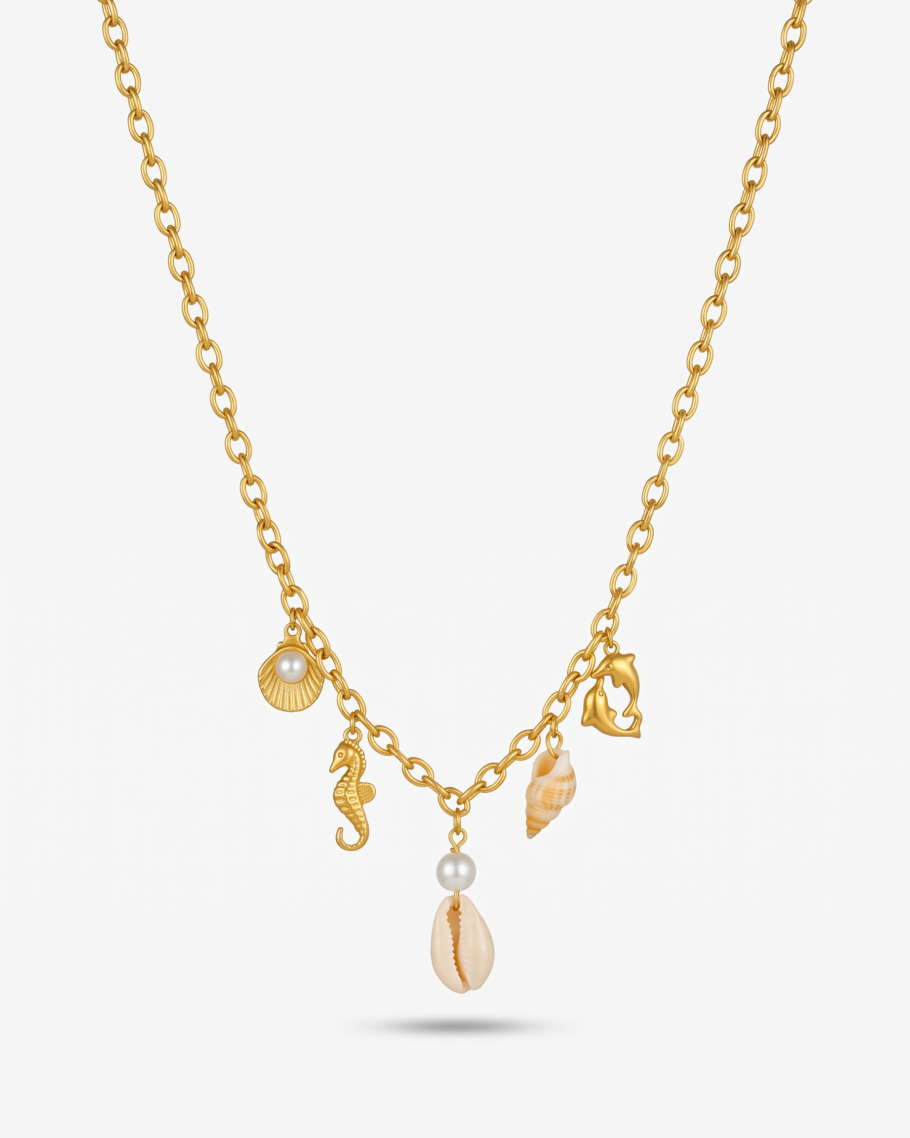 The Shore gold sea charm necklace V-hang on off white background