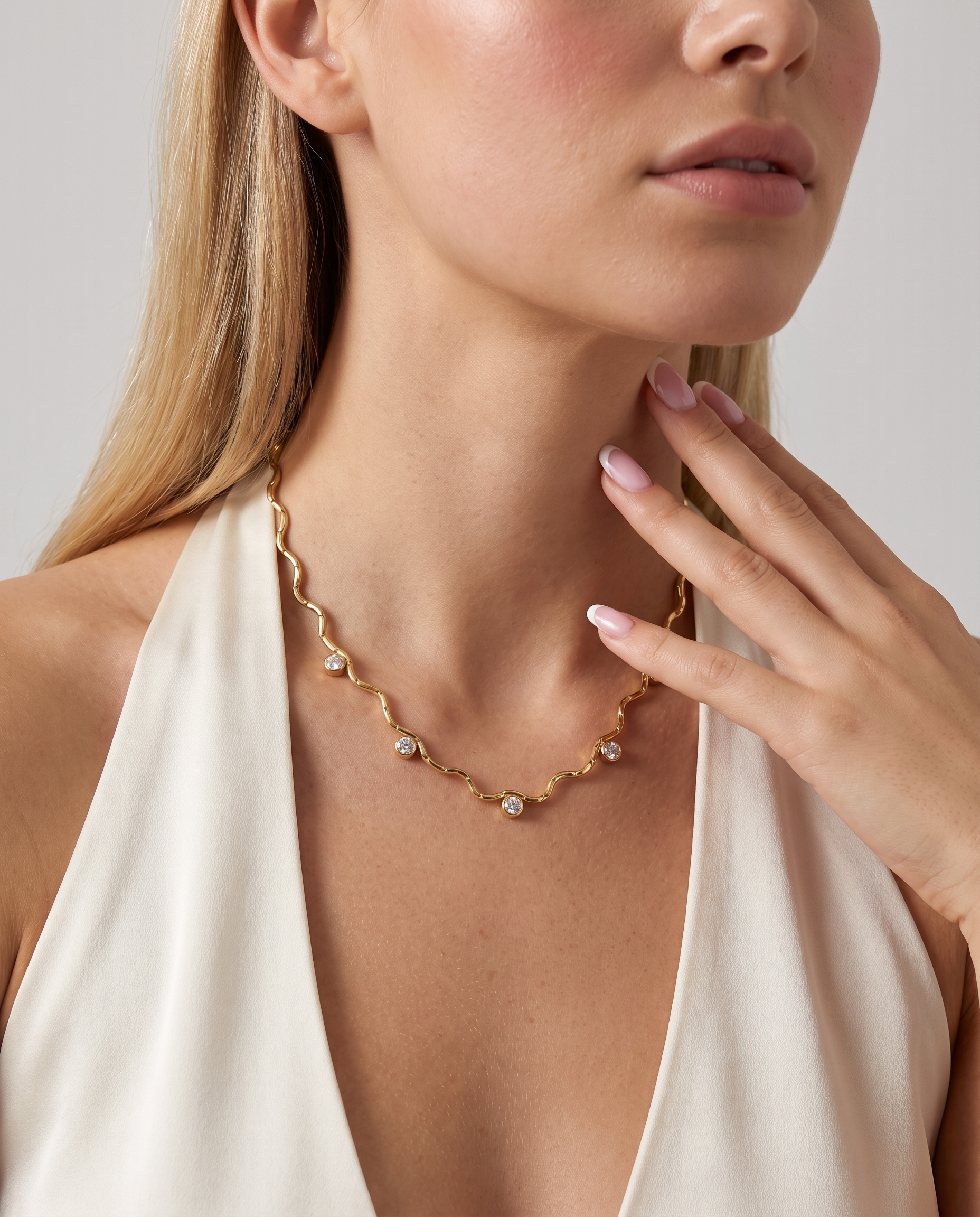 Riviere wavy gold zircon necklace worn on model at the collarbone