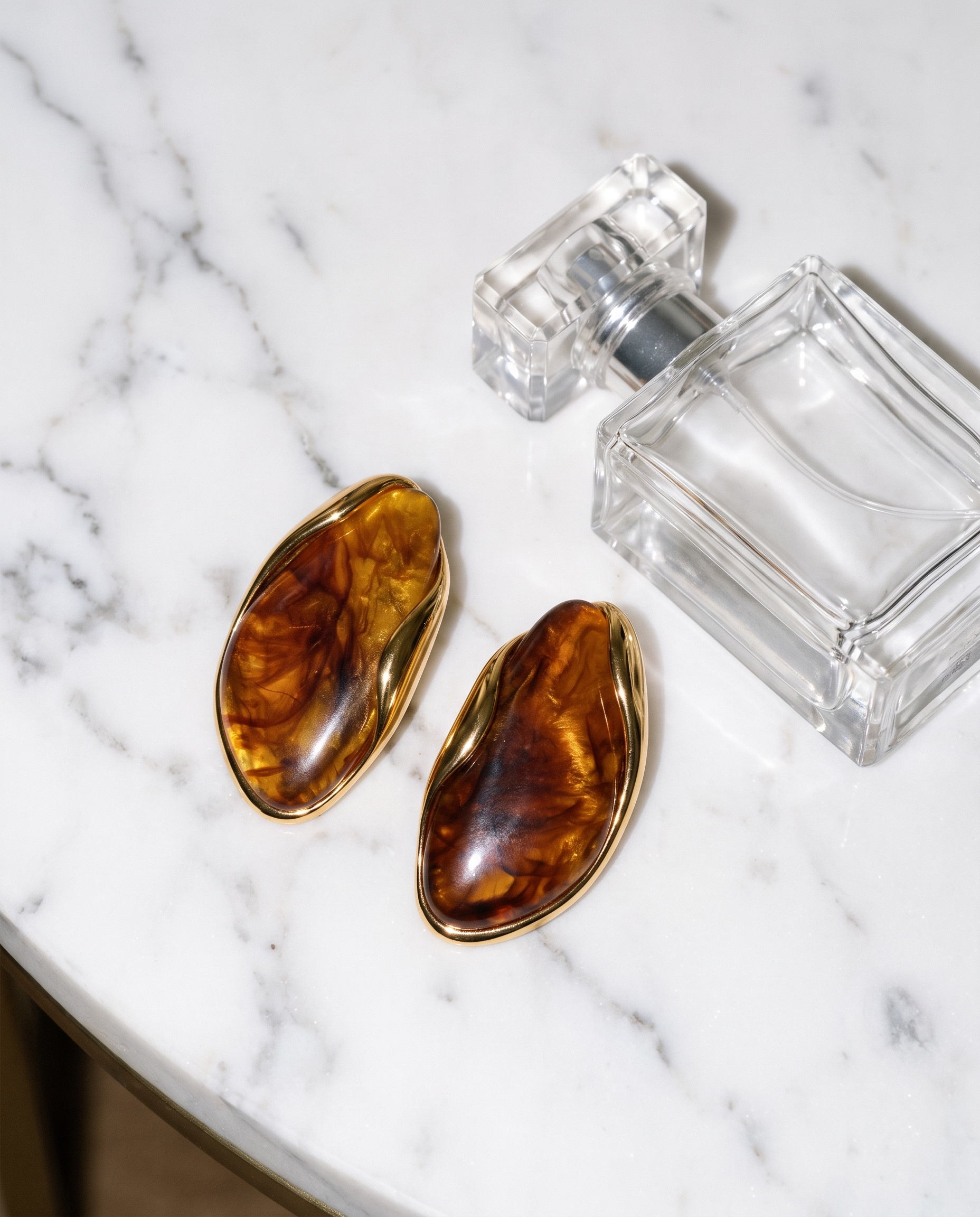 Galet amber pebble studs flatlay on marble
