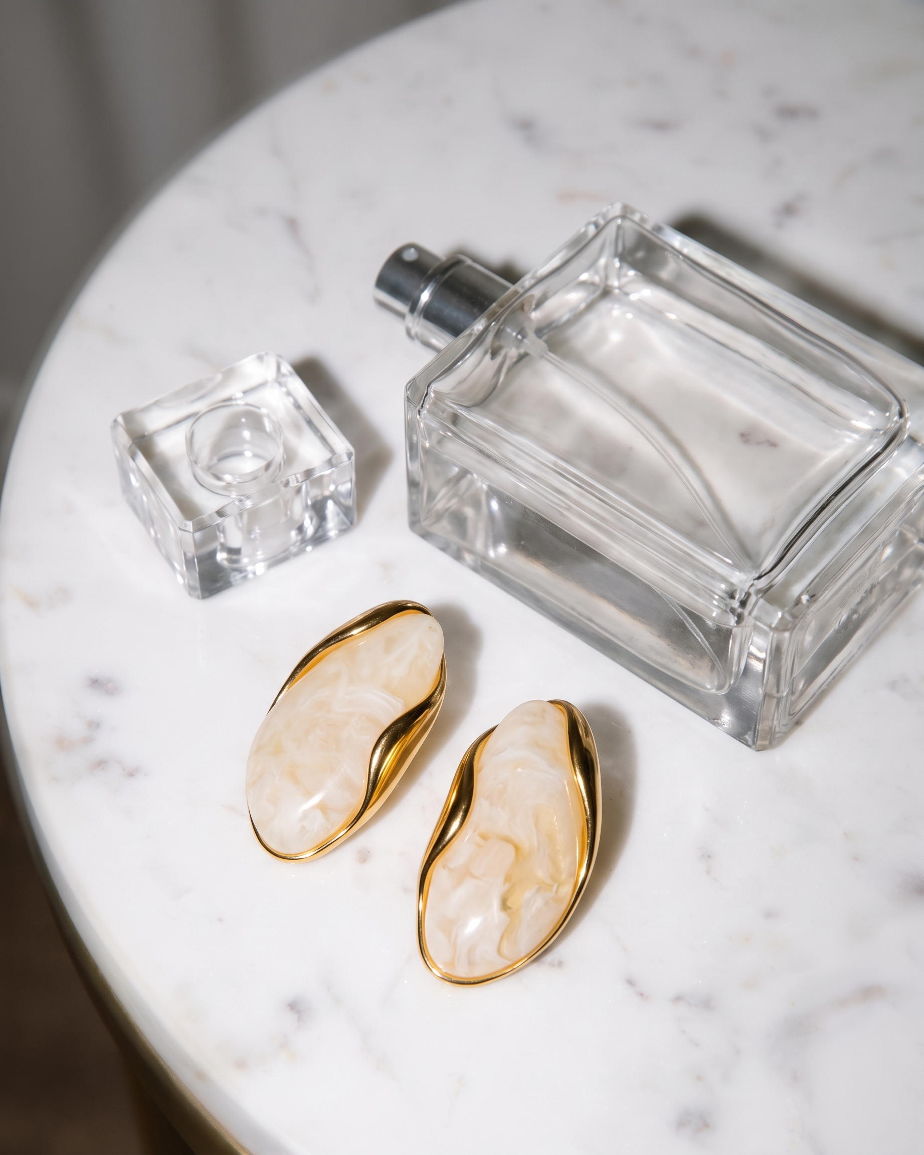 Galet cream pebble studs flatlay on marble