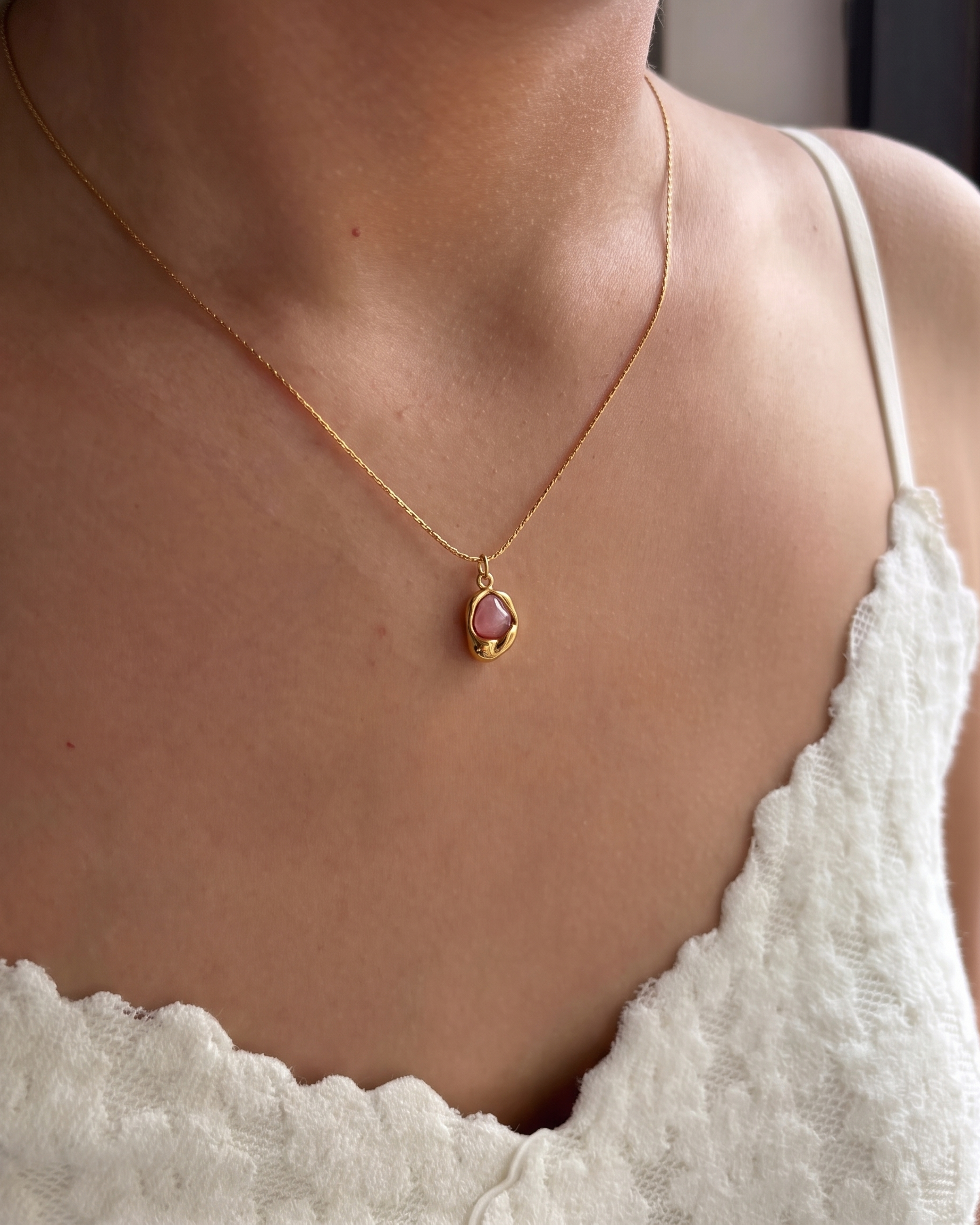 Caillou rose stone necklace worn on model in lace top