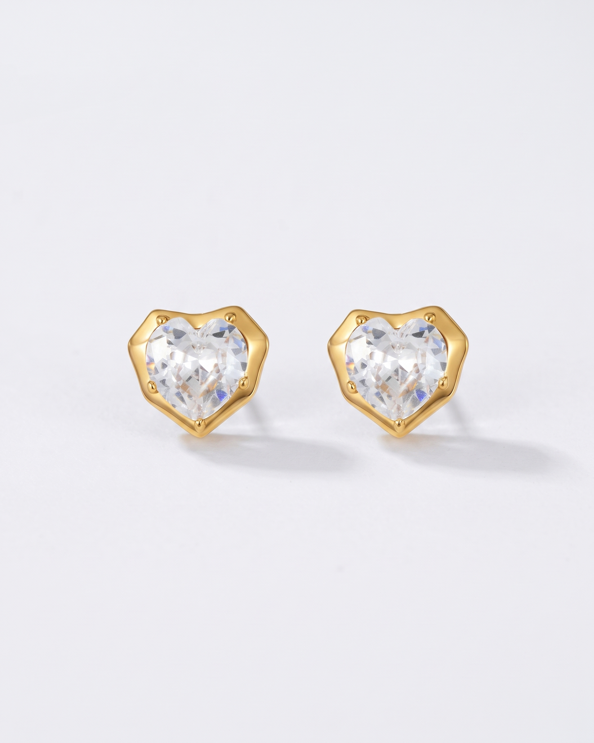Juliette heart zircon gold stud earrings on off white background