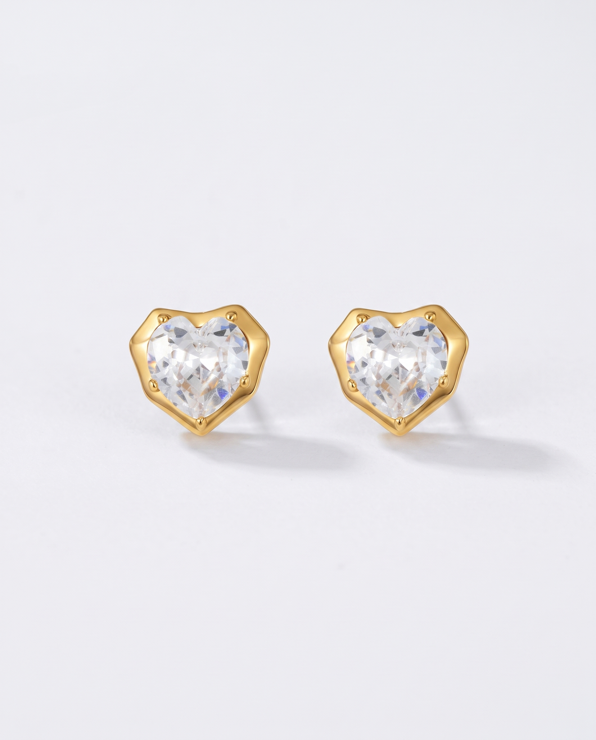 Juliette heart zircon gold stud earrings on off white background
