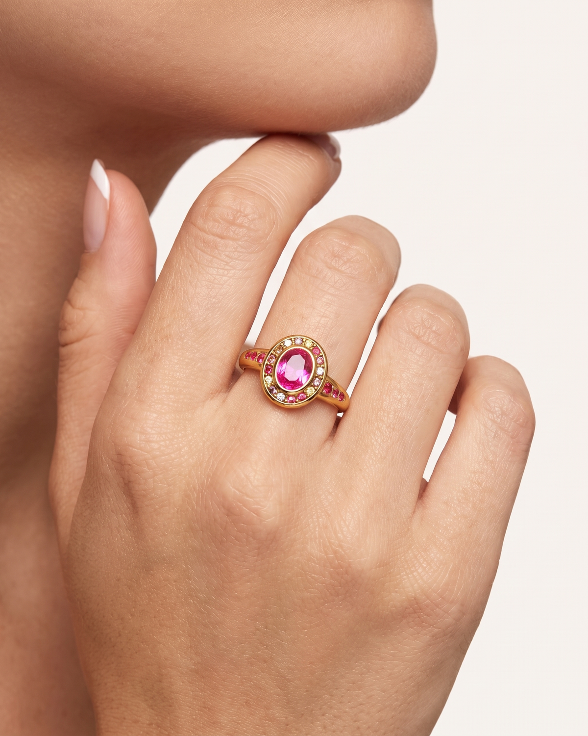 Colette gold halo ring worn on hand near face