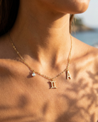 Gemini charm necklace worn, styled with birthstone and initial