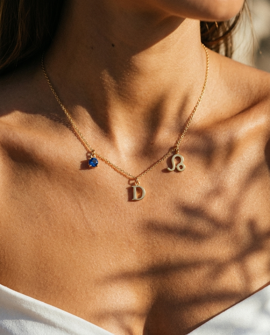 Gold initial D charm station necklace on model with Leo zodiac and sapphire