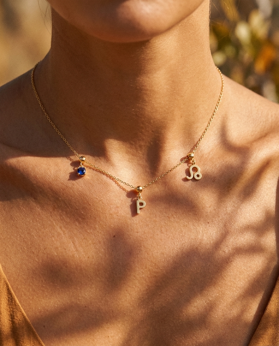 Gold initial P charm station necklace on model with Leo zodiac and sapphire