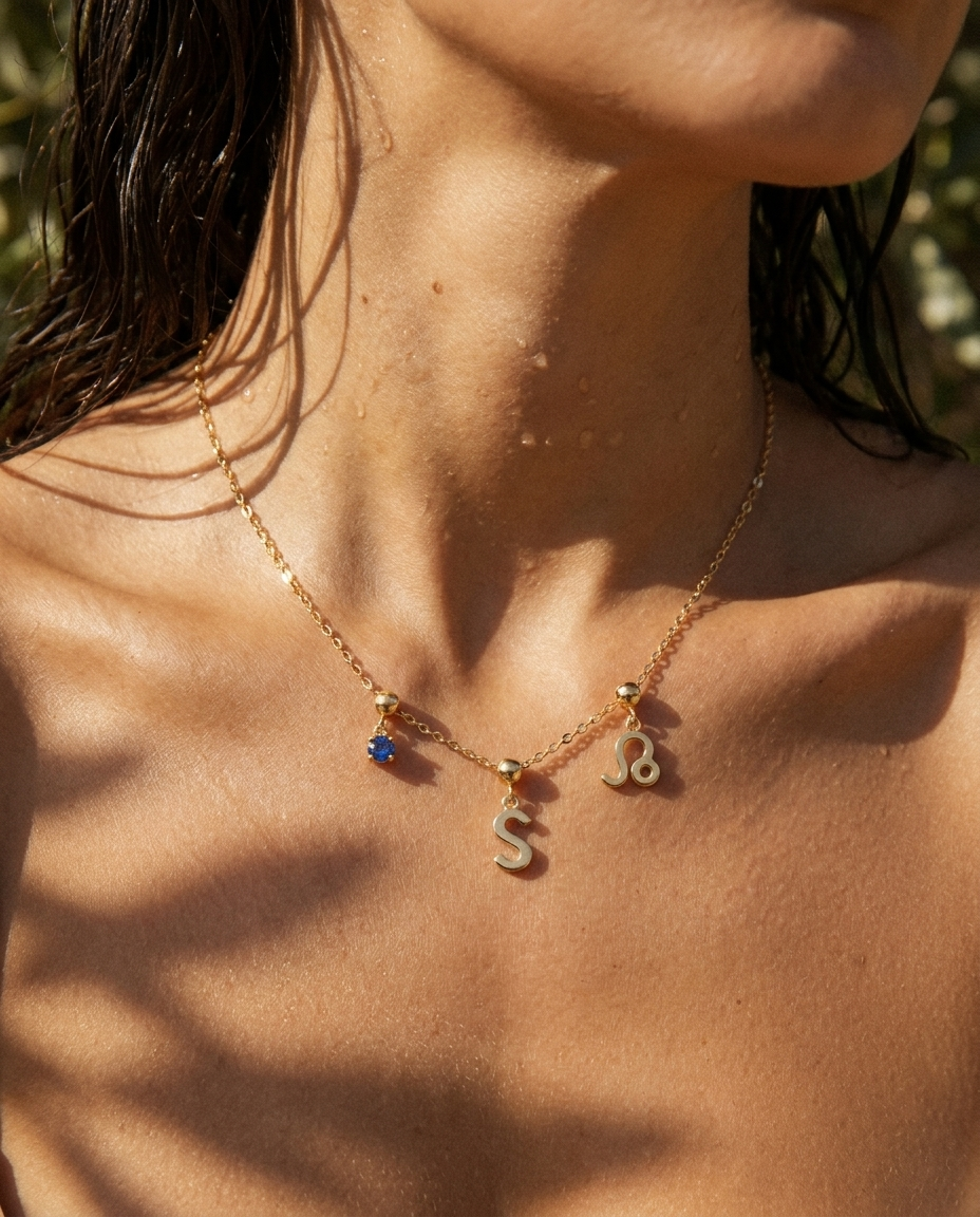 Gold initial S charm station necklace on model with Leo zodiac and sapphire