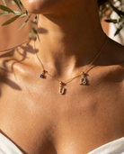 Gold initial U charm station necklace on model with Leo zodiac and sapphire