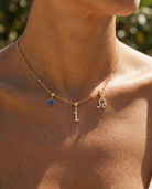 Gold number 1 charm station necklace on model with Leo zodiac and sapphire