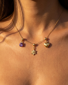 Sunburst star charm styled with February amethyst and heart on chain