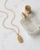 Gold zodiac Taurus pendant necklace flatlay, marble