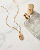 Gold zodiac Leo pendant necklace flatlay, marble