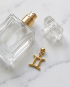 Gold zodiac Gemini charm flatlay, marble