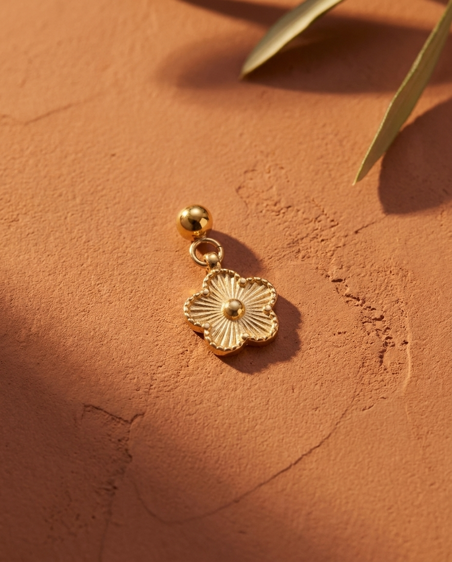 Gold daisy charm flatlay, terracotta