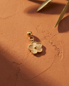 Gold daisy charm flatlay, terracotta