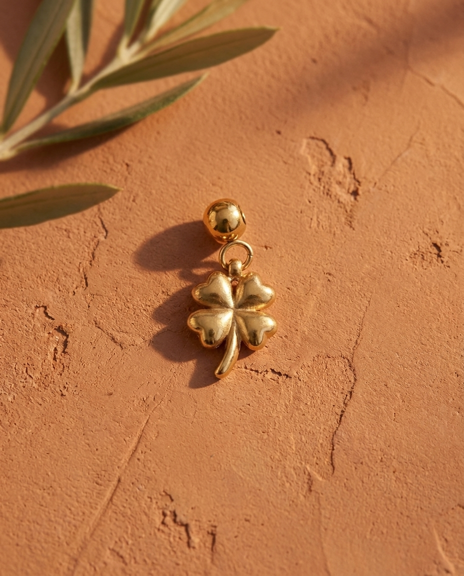 Gold quatrefoil flower charm flatlay, terracotta