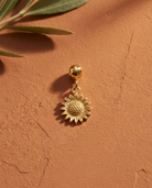 Gold sunflower charm flatlay, terracotta