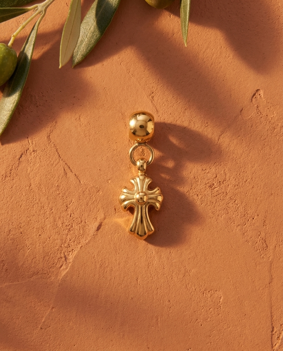 Gold cross charm flatlay, terracotta