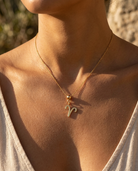 Aries gold zodiac charm on a fine gold chain necklace, worn