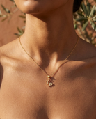 Capricorn gold zodiac charm on a fine gold chain necklace, worn
