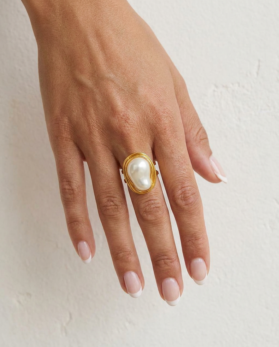 Camelia Gold Pearl Ring on hand against cream wall