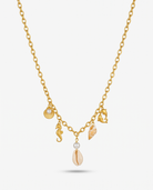 The Shore gold sea charm necklace V-hang on off white background