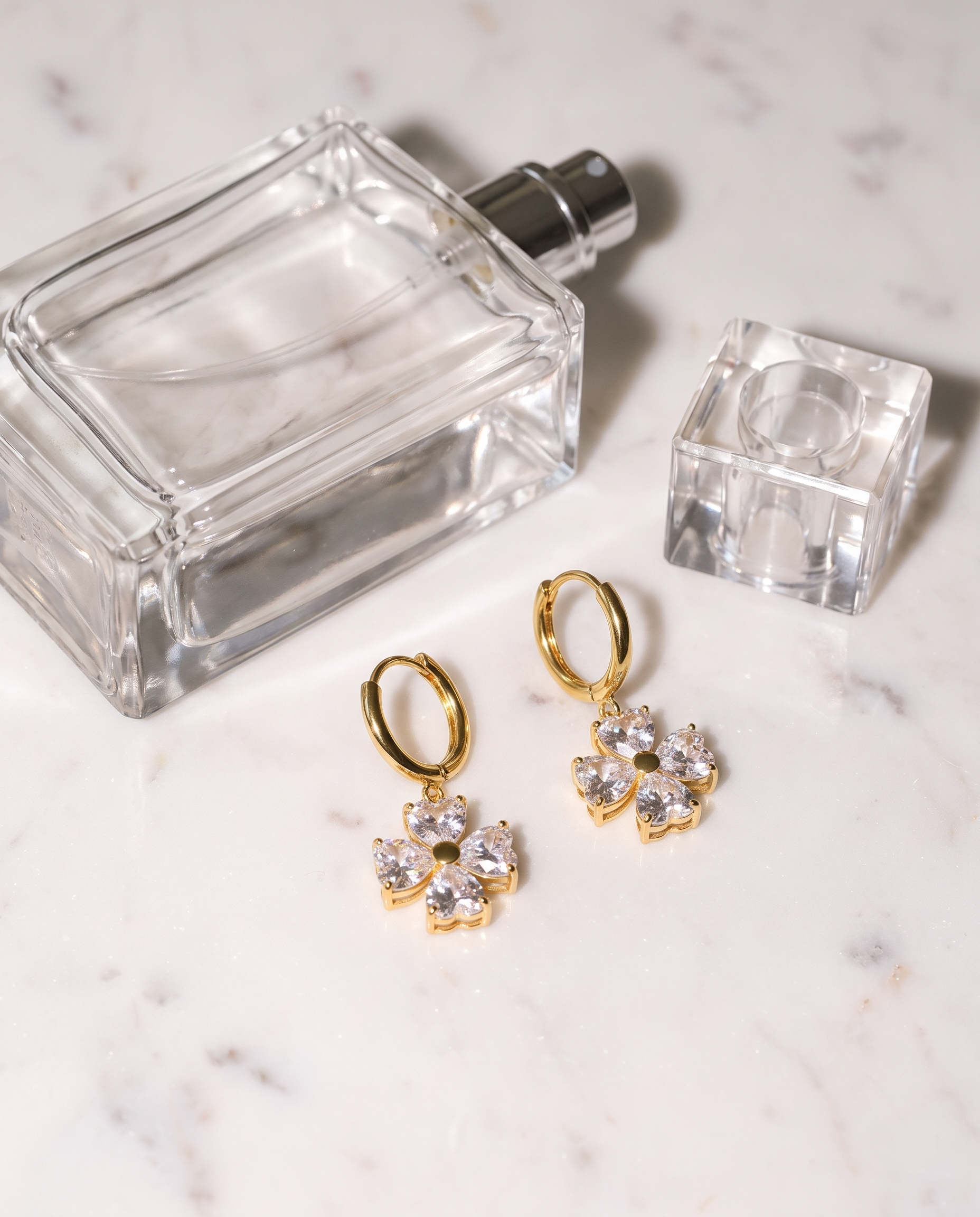 Trefle gold clover earrings flatlay on marble