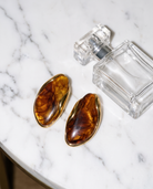 Galet amber pebble studs flatlay on marble