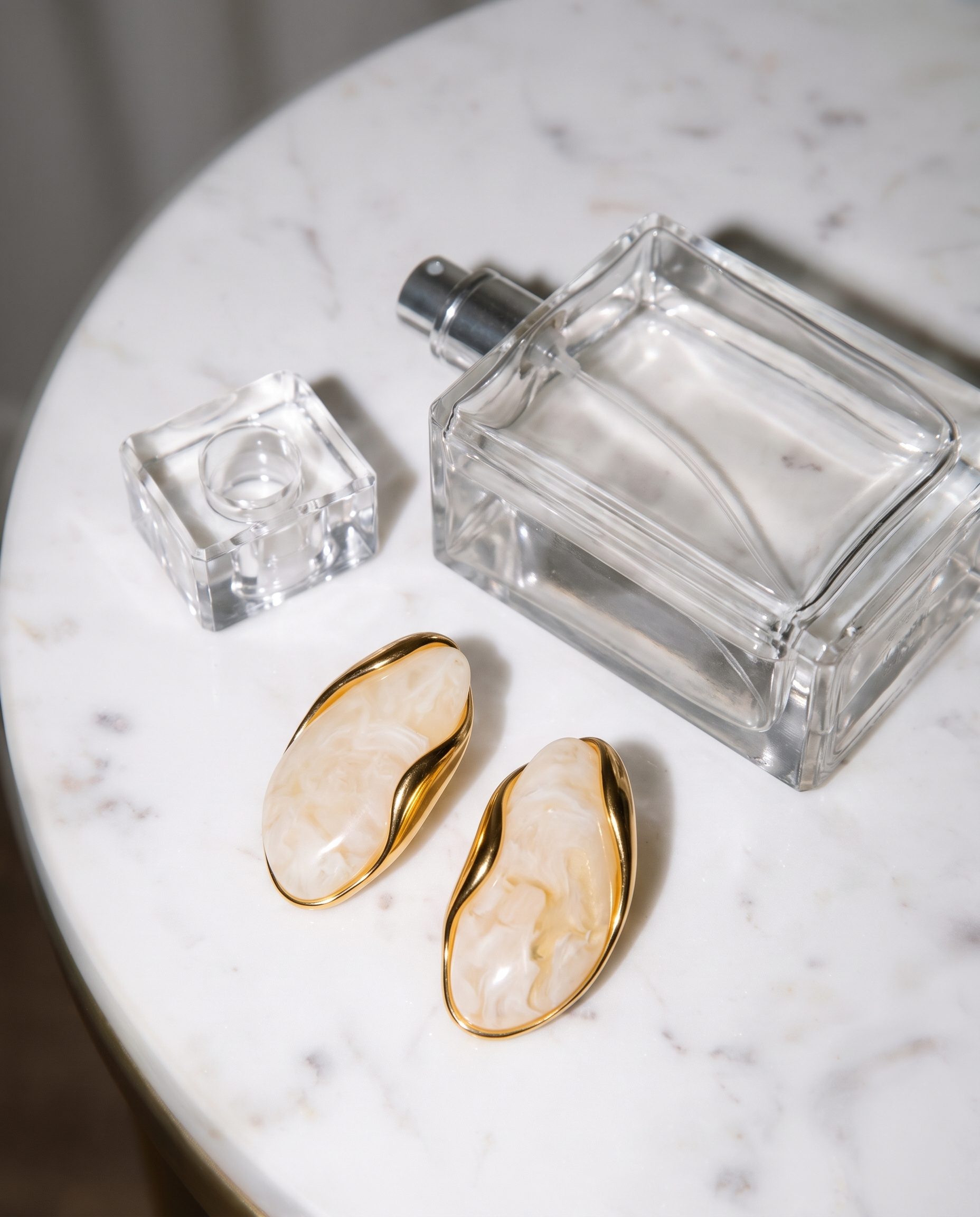 Galet cream pebble studs flatlay on marble