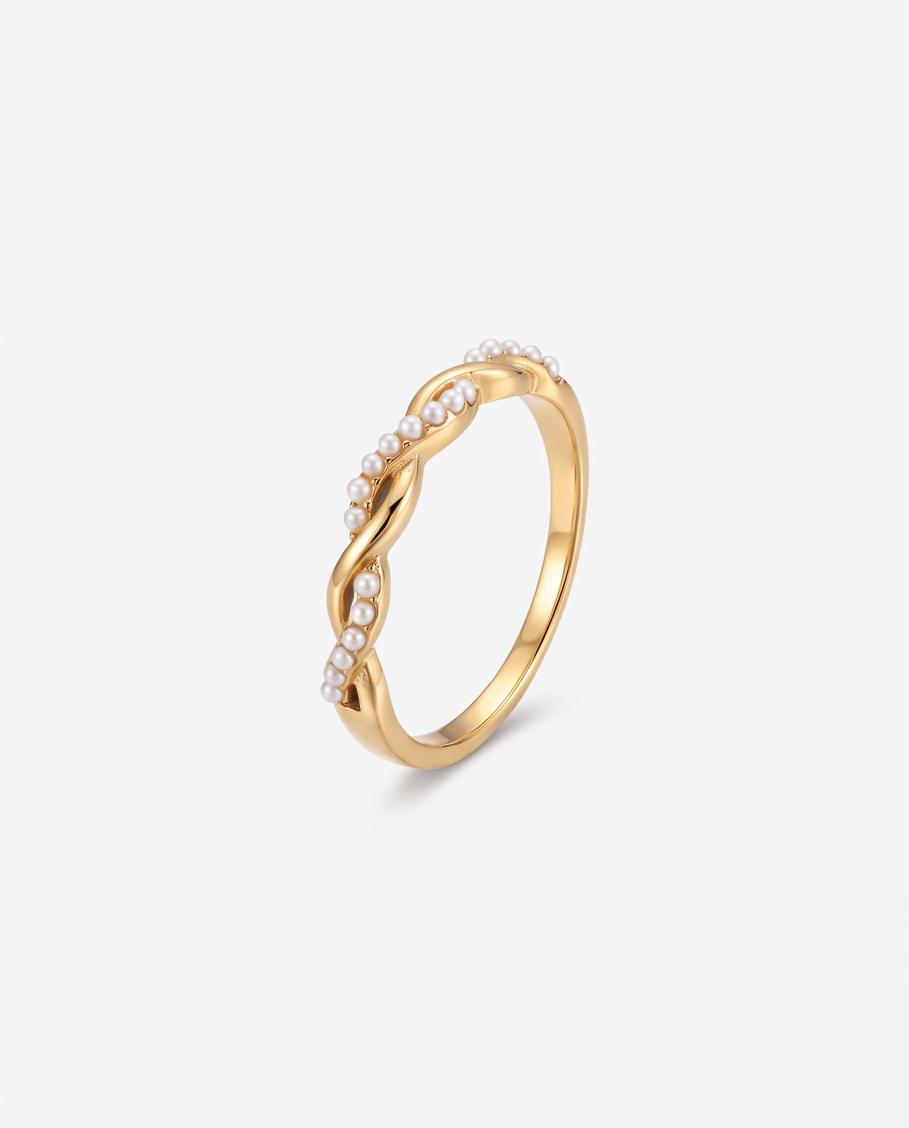 Torsade twisted pearl and gold dainty ring on off white background