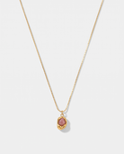 Caillou rose natural stone pendant gold necklace on off white background