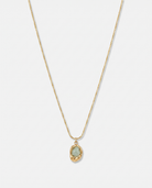 Caillou green natural stone pendant gold necklace on off white background