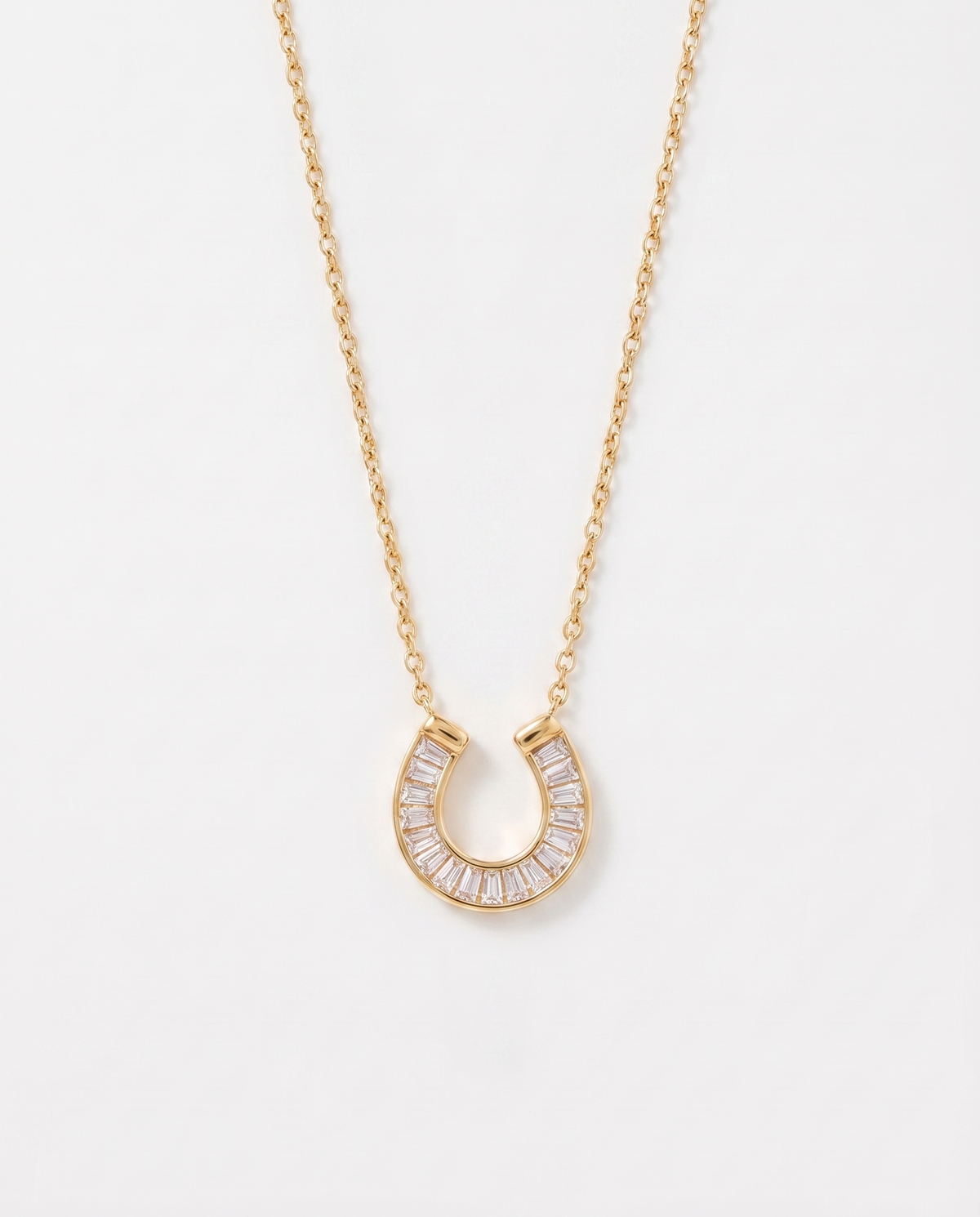 Lucky horseshoe cubic zirconia gold necklace on soft studio background