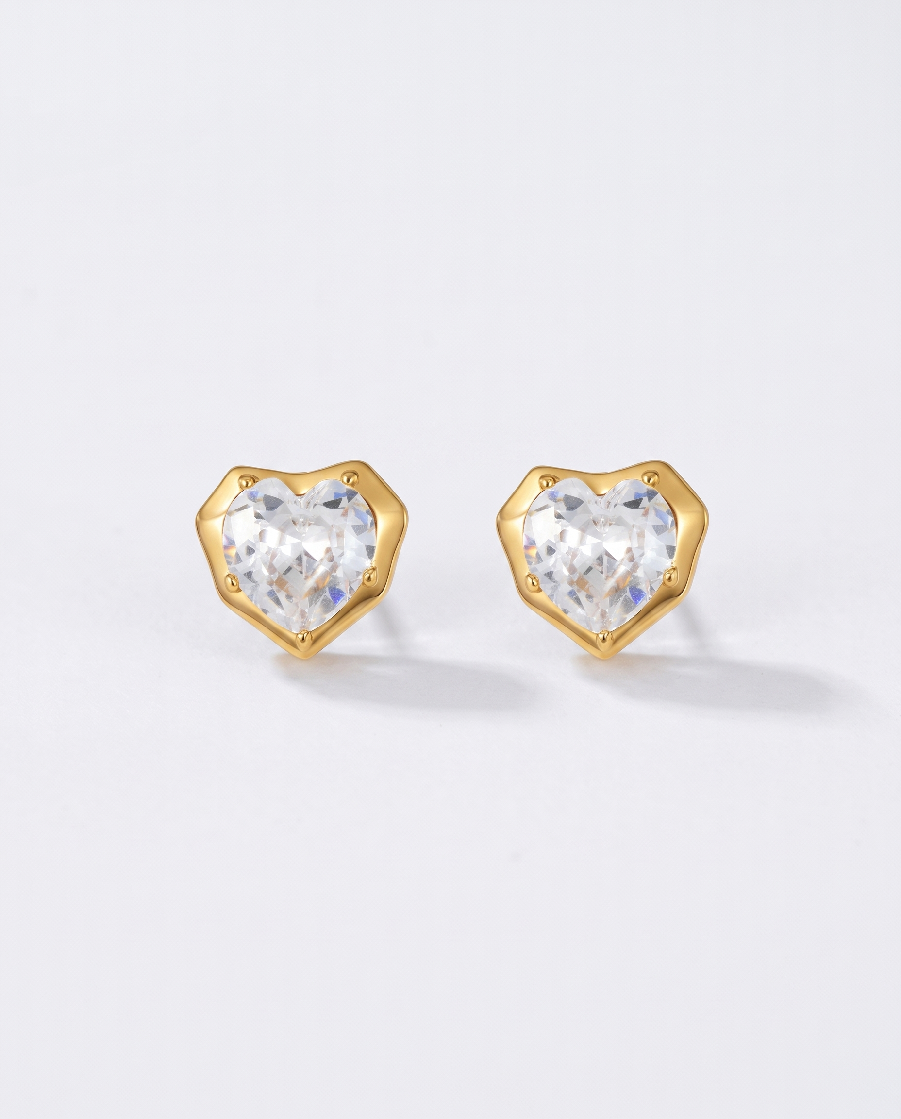 Juliette heart zircon gold stud earrings on off white background