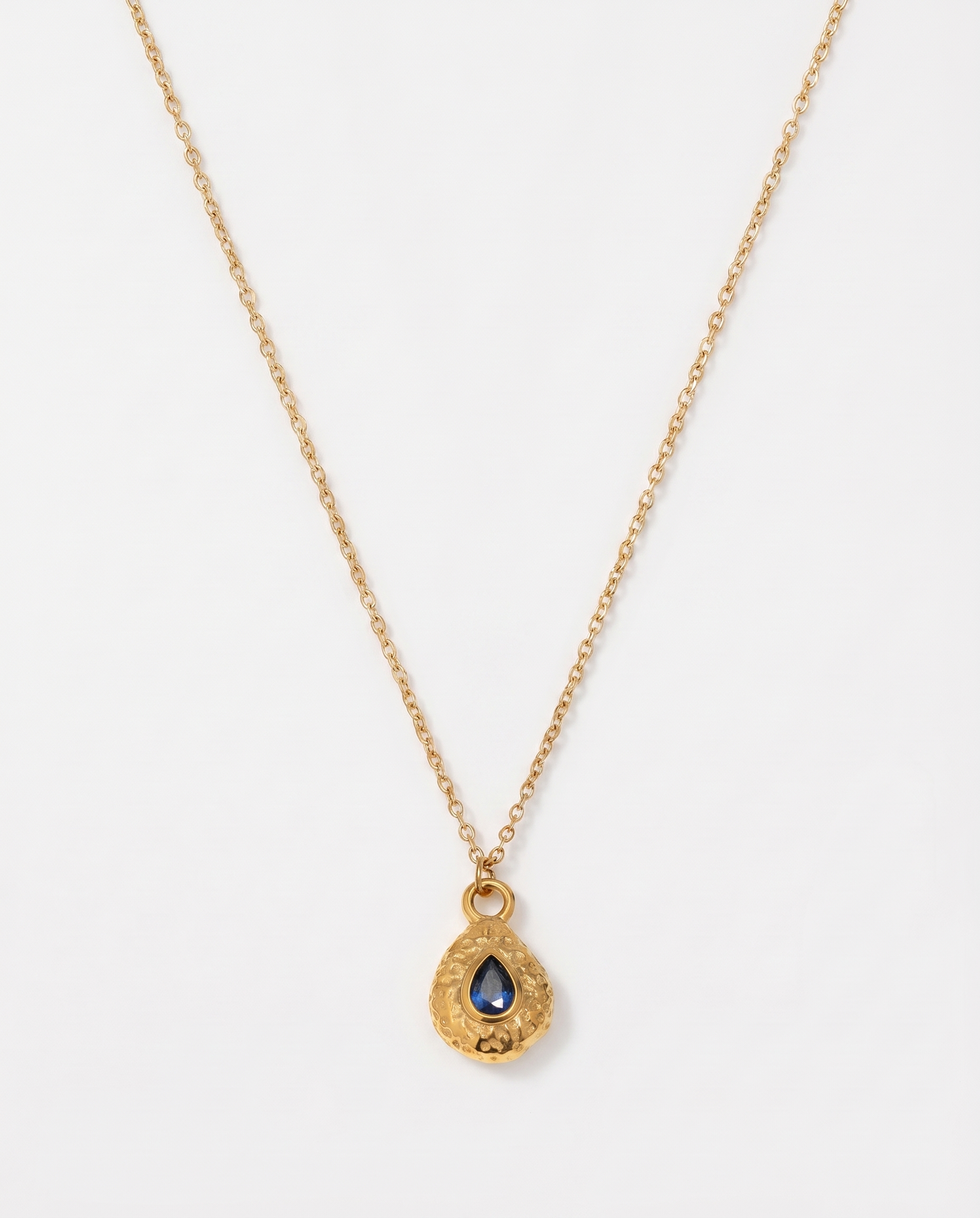 Birthstone necklace September blue teardrop gold pendant on soft studio background