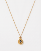 Birthstone necklace September blue teardrop gold pendant on soft studio background